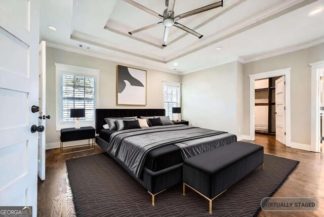 bedroom with multiple windows, a spacious closet, crown molding, and ceiling fan