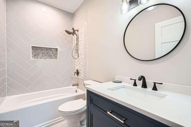 full bathroom featuring tiled shower / bath, vanity, and toilet