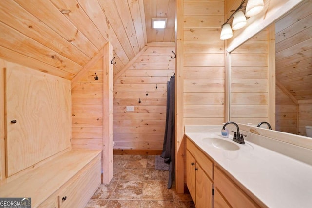 bathroom with wooden walls, vanity, wooden ceiling, and lofted ceiling