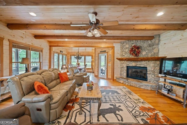 living room featuring a fireplace, plenty of natural light, beamed ceiling, and light hardwood / wood-style flooring