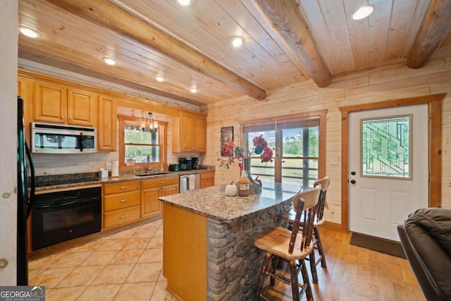 kitchen featuring beamed ceiling, light wood-type flooring, a healthy amount of sunlight, and black appliances