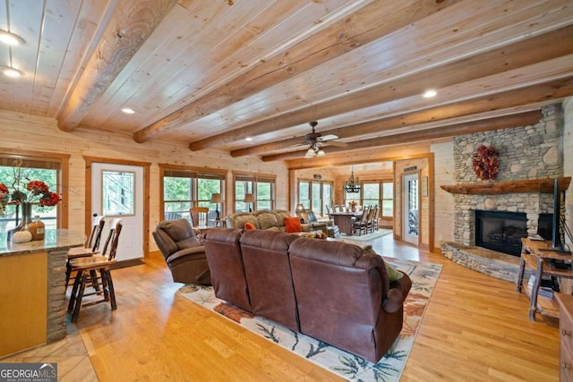 living room with beam ceiling, light hardwood / wood-style flooring, and a healthy amount of sunlight