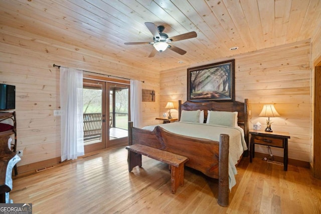 bedroom featuring wood walls, access to outside, french doors, light wood-type flooring, and wood ceiling