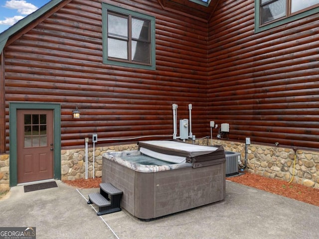 view of patio with a hot tub and central AC