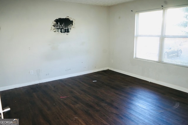 empty room with a textured ceiling and dark wood-type flooring