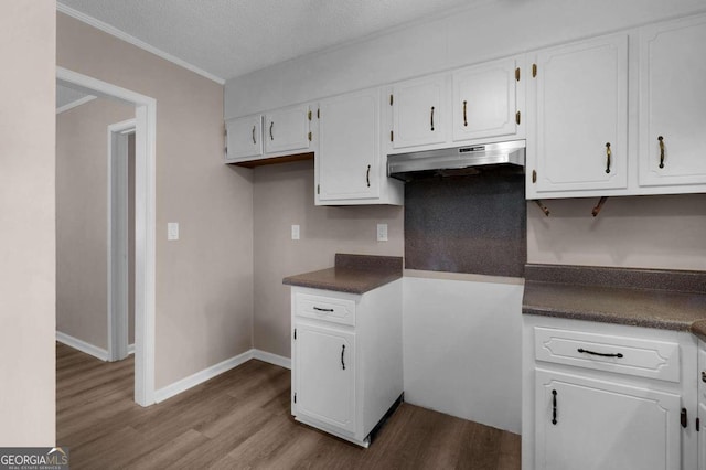 kitchen featuring white cabinetry, ornamental molding, a textured ceiling, and light wood-type flooring