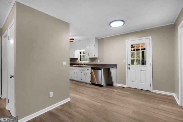 kitchen with white cabinets, light wood-type flooring, stainless steel dishwasher, and ceiling fan