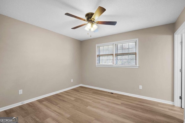 unfurnished bedroom featuring ceiling fan, light wood-type flooring, and a textured ceiling