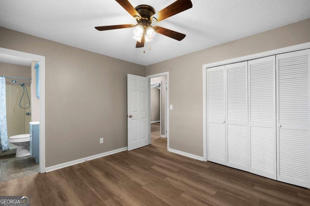 unfurnished bedroom featuring a closet, ensuite bathroom, dark hardwood / wood-style floors, and ceiling fan