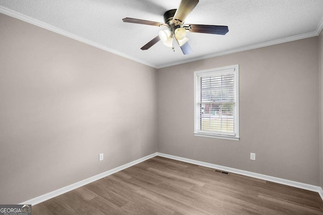 empty room featuring a textured ceiling, ceiling fan, wood-type flooring, and ornamental molding