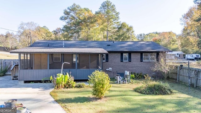 back of house featuring a sunroom and a yard