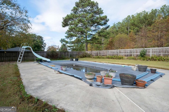 view of swimming pool with a patio area and a water slide