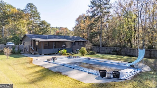 view of swimming pool featuring a diving board, a patio area, a sunroom, a water slide, and a lawn