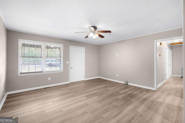 spare room featuring ceiling fan, light hardwood / wood-style flooring, crown molding, and a textured ceiling