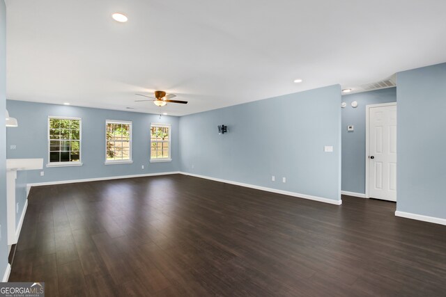 empty room with ceiling fan and dark wood-type flooring