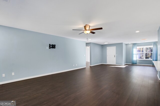 unfurnished room with ceiling fan and dark wood-type flooring