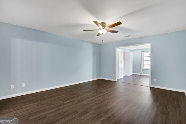 unfurnished room with ceiling fan and dark wood-type flooring