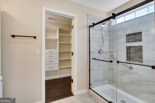 bathroom with wood-type flooring and walk in shower