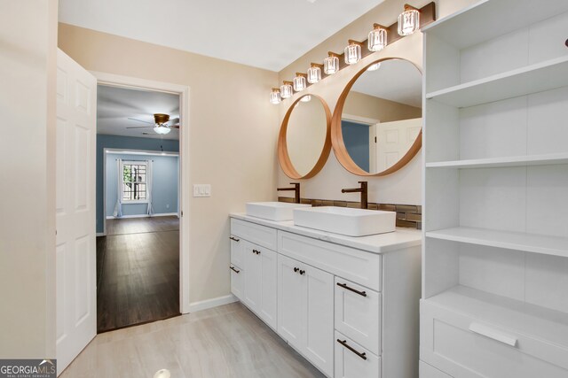 bathroom with hardwood / wood-style floors, ceiling fan, and vanity