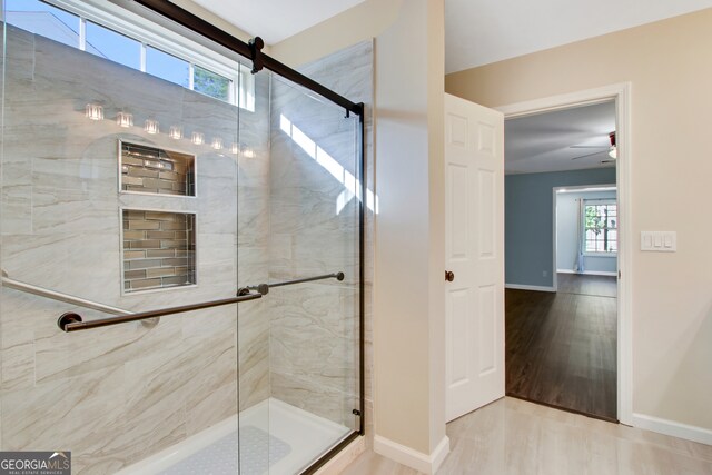 bathroom with ceiling fan, hardwood / wood-style floors, a healthy amount of sunlight, and an enclosed shower