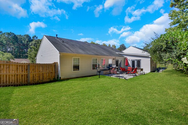 rear view of house featuring a lawn and a patio area