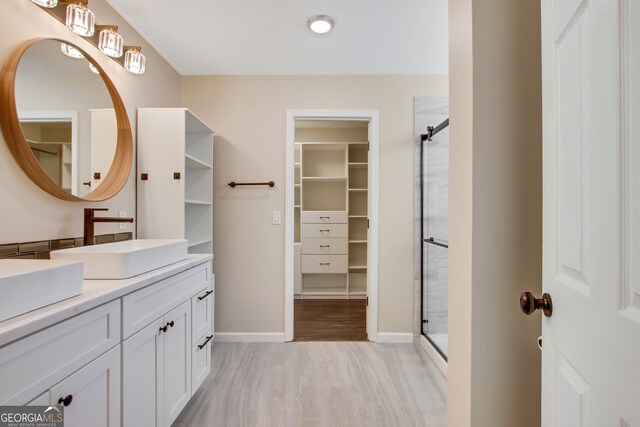 bathroom featuring vanity, wood-type flooring, and walk in shower