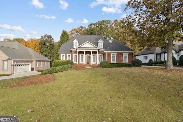 cape cod home featuring covered porch, a front yard, and a garage