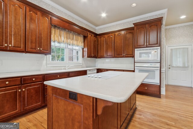 kitchen with a center island, light wood-type flooring, white appliances, and ornamental molding