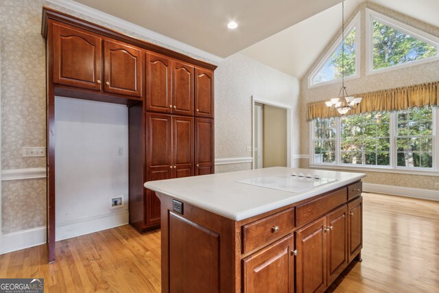 kitchen featuring an inviting chandelier, white electric cooktop, decorative light fixtures, vaulted ceiling, and light wood-type flooring