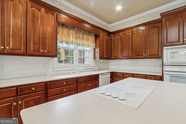 kitchen with sink, white appliances, ornamental molding, and backsplash