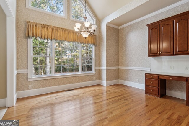 unfurnished dining area featuring a notable chandelier, lofted ceiling, a healthy amount of sunlight, and light wood-type flooring