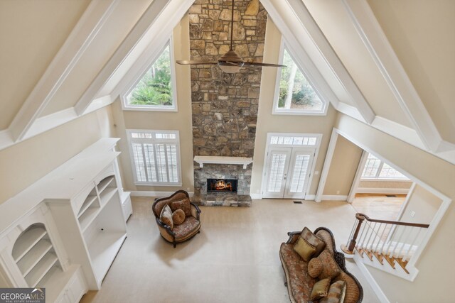 living room featuring a fireplace, a towering ceiling, and plenty of natural light