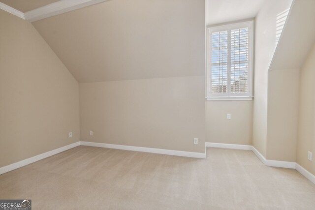 bonus room with light colored carpet and lofted ceiling