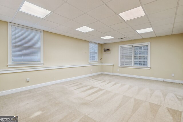 unfurnished room with a paneled ceiling and light colored carpet