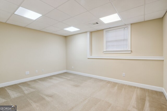 carpeted spare room with a paneled ceiling