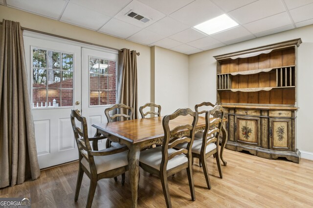 dining room featuring a paneled ceiling, hardwood / wood-style floors, and french doors