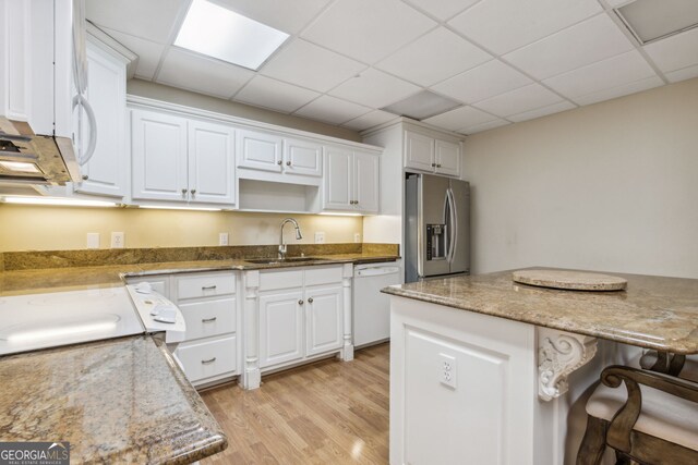 kitchen featuring sink, white cabinets, white appliances, and light wood-type flooring