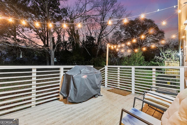 deck at dusk featuring grilling area