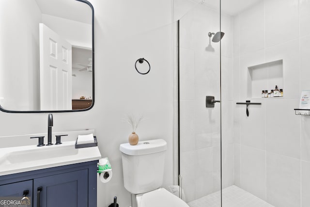 bathroom featuring tiled shower, vanity, and toilet