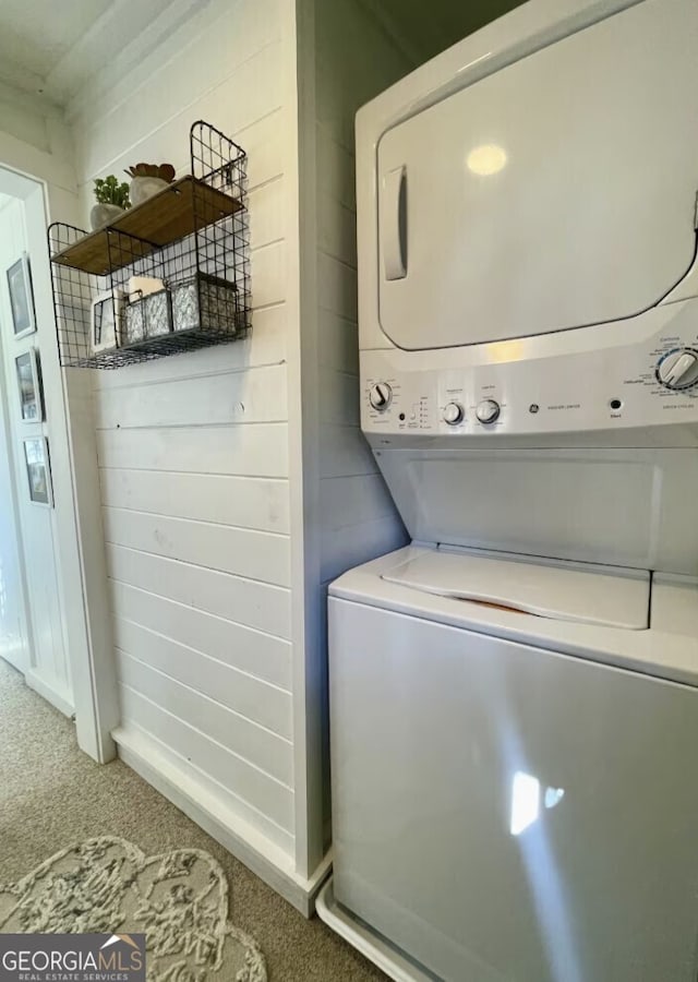 laundry room featuring carpet and stacked washer and clothes dryer