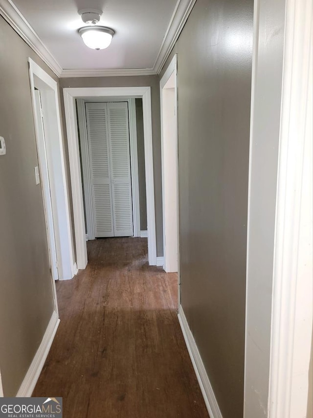 corridor with dark hardwood / wood-style flooring and crown molding