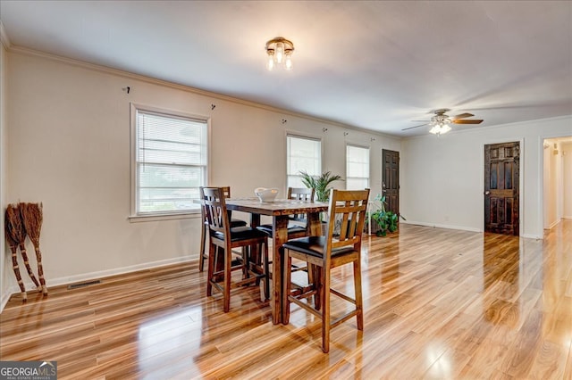 dining room with ceiling fan, light hardwood / wood-style floors, and crown molding