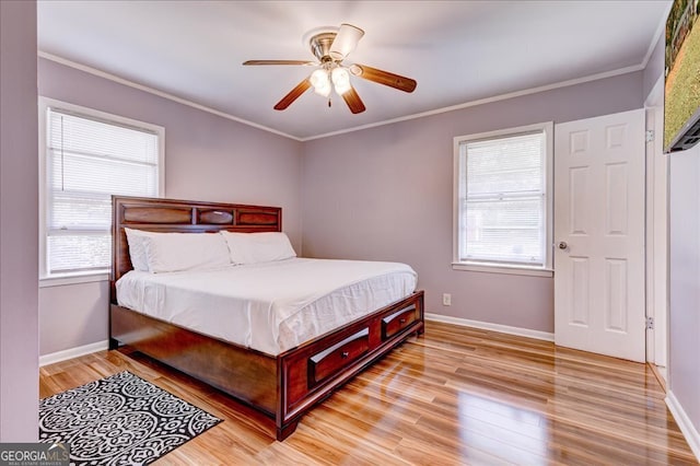 bedroom featuring ceiling fan, crown molding, light hardwood / wood-style flooring, and multiple windows