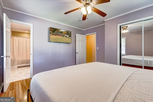 bedroom featuring light wood-type flooring, ornamental molding, ceiling fan, connected bathroom, and a closet