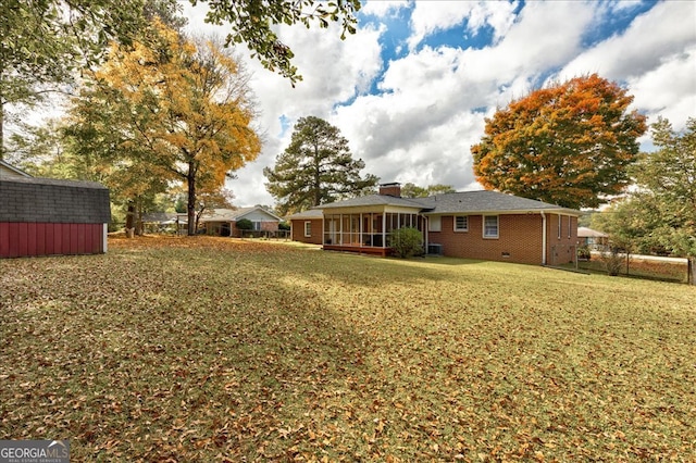 view of yard featuring a sunroom and a storage unit