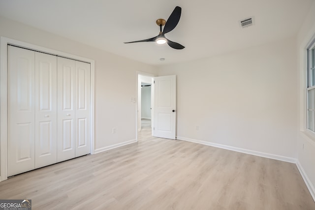 unfurnished bedroom with a closet, light hardwood / wood-style flooring, and ceiling fan