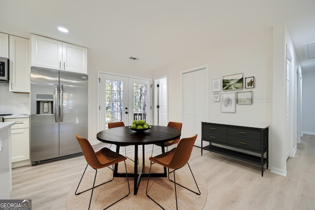 dining area with french doors and light hardwood / wood-style floors