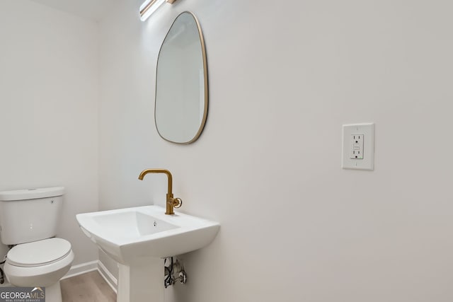 bathroom with hardwood / wood-style flooring, toilet, and sink