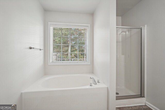 bathroom featuring shower with separate bathtub