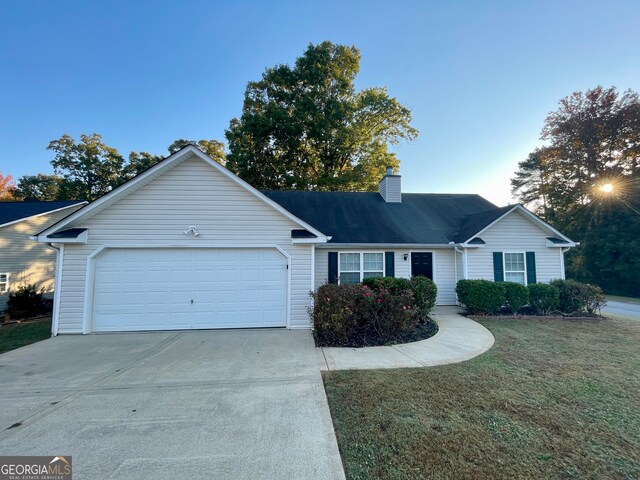 single story home with a garage and a front lawn